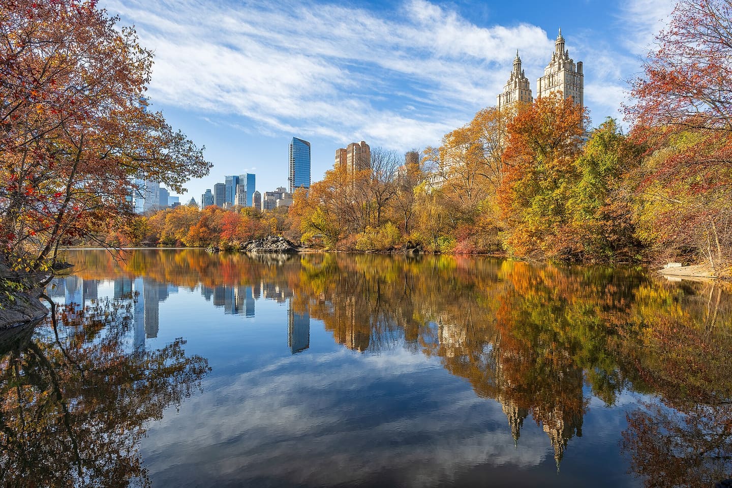 Central Park in autumn with the Manhattan skyline reflected in the lake