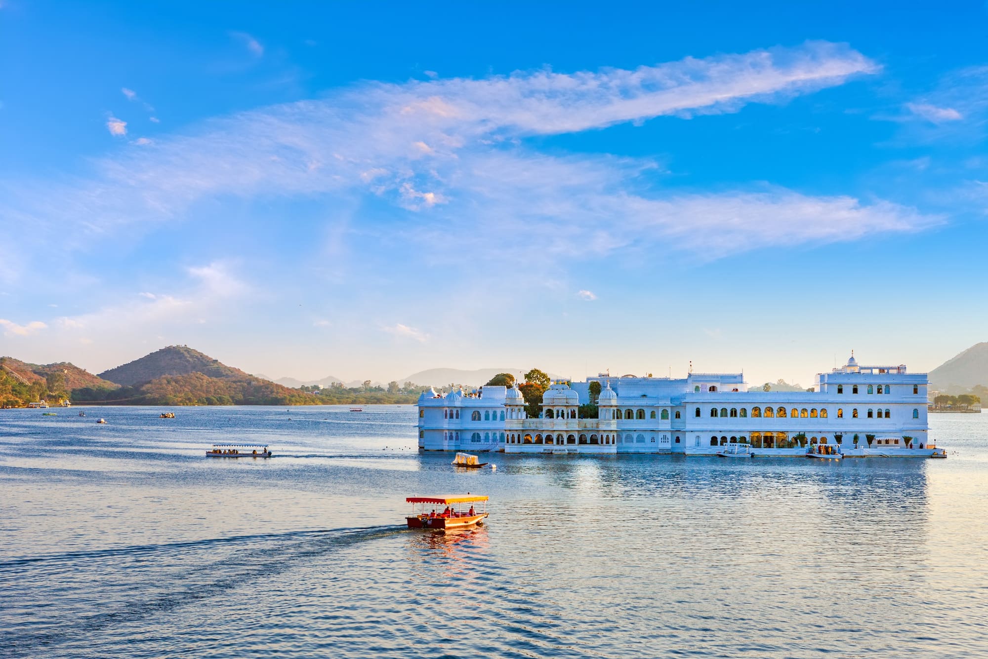The Lake Palace on Lake Pichola in Udaipur with a boat passing